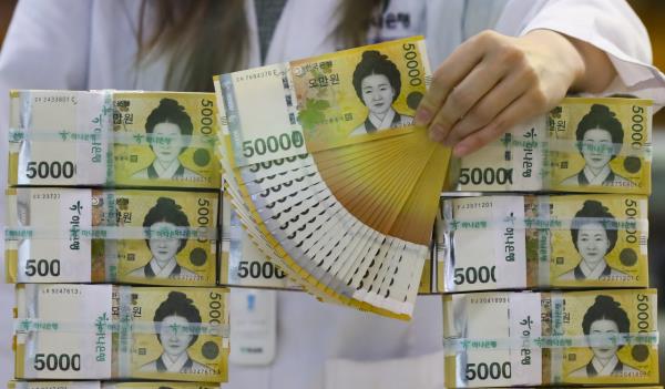 一名职员在首尔的一家银行检查5万韩元纸币。(Newsis)